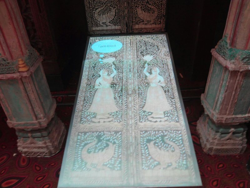 Close view of the lit floor panel showing carved figures